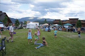 Guests can enjoy outdoor events in a scenic setting surrounded by a grassy field, tents, and nearby buildings.