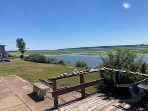 A wooden deck with a stone bench, a small table, and a chair. - 50' from the Mississippi River, see the winter eagle migration, fish from there (Montrose)