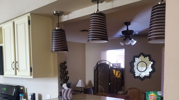 A kitchen with a granite countertop, two wooden bar stools, hanging pendant lights, and a microwave. - Pet-friendly, Family-friendly & Fun-Friendly Central-to-Everything Phoenix Home (Phoenix)