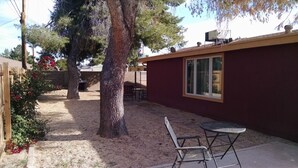 A patio area with a table and chairs, a small building with a window, and a tree. - Pet-friendly, Family-friendly & Fun-Friendly Central-to-Everything Phoenix Home (Phoenix)