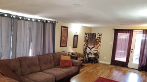 A living room with a brown sofa, a wooden coffee table, and a red rug. - Pet-friendly, Family-friendly & Fun-Friendly Central-to-Everything Phoenix Home (Phoenix)