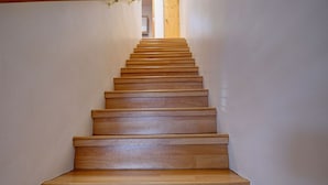 A wooden staircase with a handrail on the left, leading to a door at the top. - Casita F - 2 Bed, 1.5 Bath (Two Story) (Santa Fe)