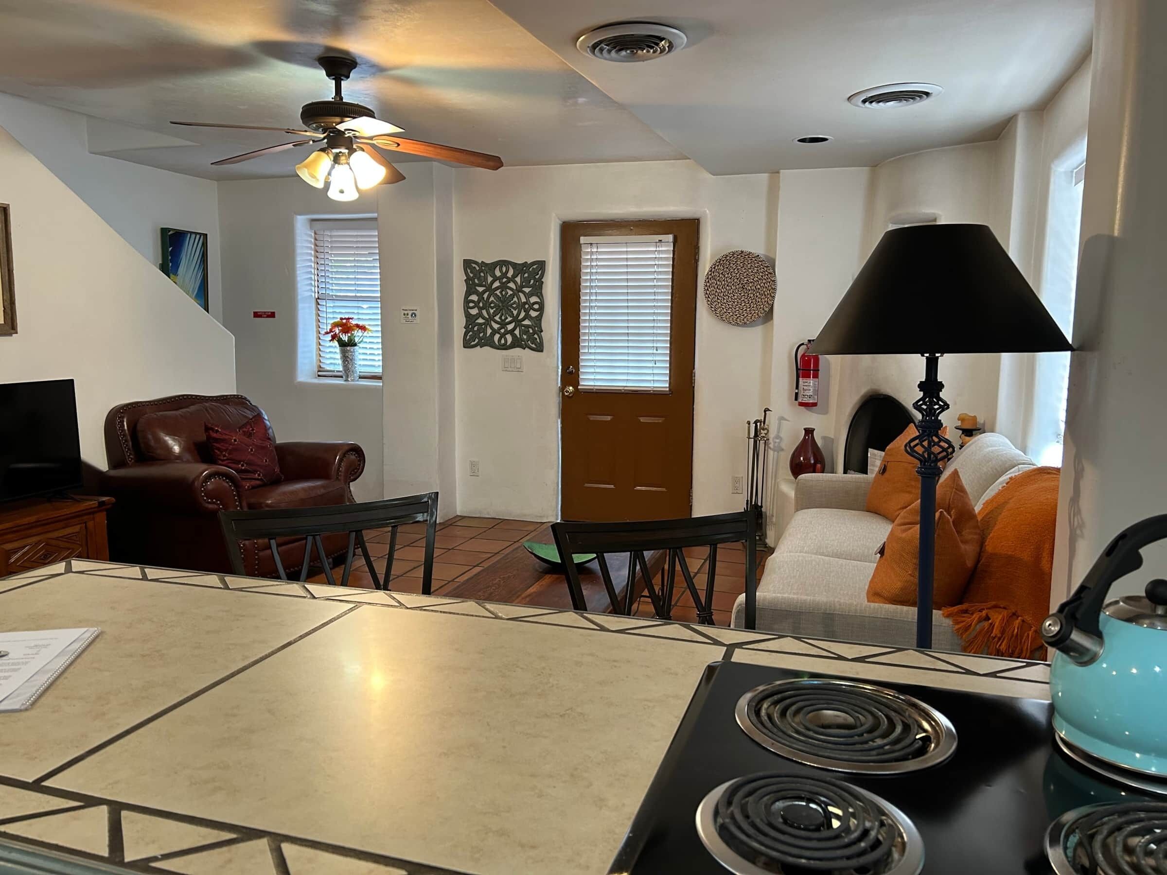 Una sala de estar con una mesa de comedor, un sofá, un televisor y un ventilador de techo.