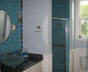 Un baño con lavabo, espejo y ducha.