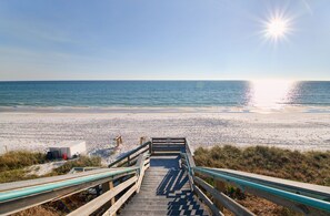 A wooden staircase leading to a beach with a clear sky and sun reflecting on the water. - Sunset Veranda -100 Steps To The Beach and Pool Between Rosemary/Alys Beach (Panama City Beach)