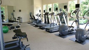 A gym with treadmills, elliptical machines, and a weight bench.