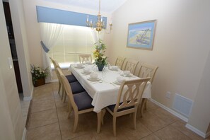 Ein Esszimmer mit einem großen Tisch, gedeckt für sechs Personen, umgeben von sechs Stühlen.