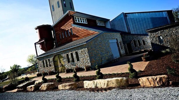A modern building with a stone facade, a wooden sloped roof, and a tall tower. - Cozy Cabin center of Bourbon Trail, Near Bardstown, beautiful country views (Springfield)