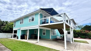 A two-story house with a covered porch and a second-level balcony.