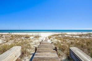 A wooden boardwalk leading to a beach with clear skies. - Sea Salt Cottage: Amazing home located on the Gulf of Mexico. Sleeps 13 comfortably! (Navarre)