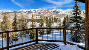 A wooden deck with a railing overlooking a snowy mountain landscape. - Ski-in, Quick Walk to Slopes with AMAZING VIEWS (Mt Crested Butte)