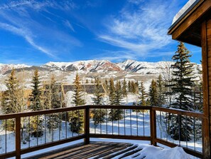 A wooden deck with a railing overlooking a snowy mountain landscape. - Ski-in, Quick Walk to Slopes with AMAZING VIEWS (Mt Crested Butte)