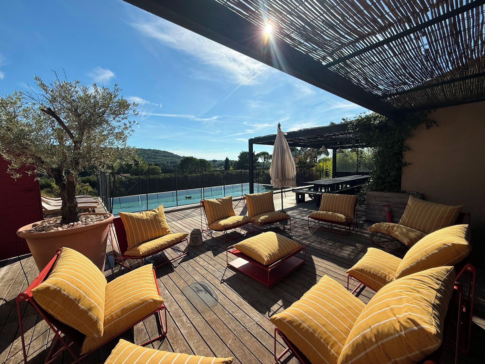 Eine Terrasse mit Sitzgelegenheiten im Freien, einem Pool und Blick auf die Landschaft.