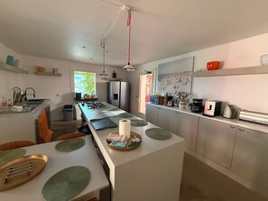 A modern kitchen with a central island, stainless steel appliances, and a view of the outdoors. - Stunning and spacious home in Provence! (Lourmarin)