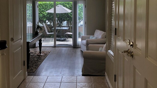 A hallway leading to a living area with a sliding glass door to an outdoor patio. - "Welcome to Your Ultimate Huntington Beach Get-a-way! 3-Blocks to the Beach!  (Huntington Beach)