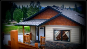 A small cabin with a porch, a door, and a window. - Luxury Walk Out House in Radium Hot Springs 5 Bedrooms (Radium Hot Springs)