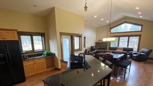 A spacious kitchen with a central island, wooden cabinets, and a large window. - Luxury Walk Out House in Radium Hot Springs 5 Bedrooms (Radium Hot Springs)