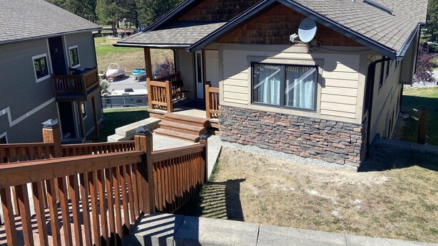 A two-story house with a stone foundation and a sloped roof. - Luxury Walk Out House in Radium Hot Springs 5 Bedrooms (Radium Hot Springs)