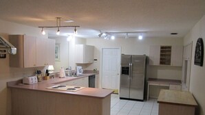 A compact kitchen with a central island, a refrigerator, and a dishwasher.