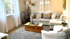 A cozy living room with a sofa, a wooden chest, and a lamp.