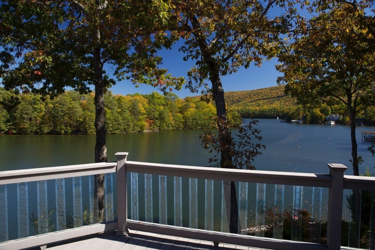 Vista al lago con muelle y barandilla de madera.