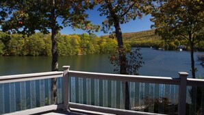 A lakeside view with a wooden deck and railing. - Wind Family Estate--7000sq feet with 7 flex rooms! (Huddleston)
