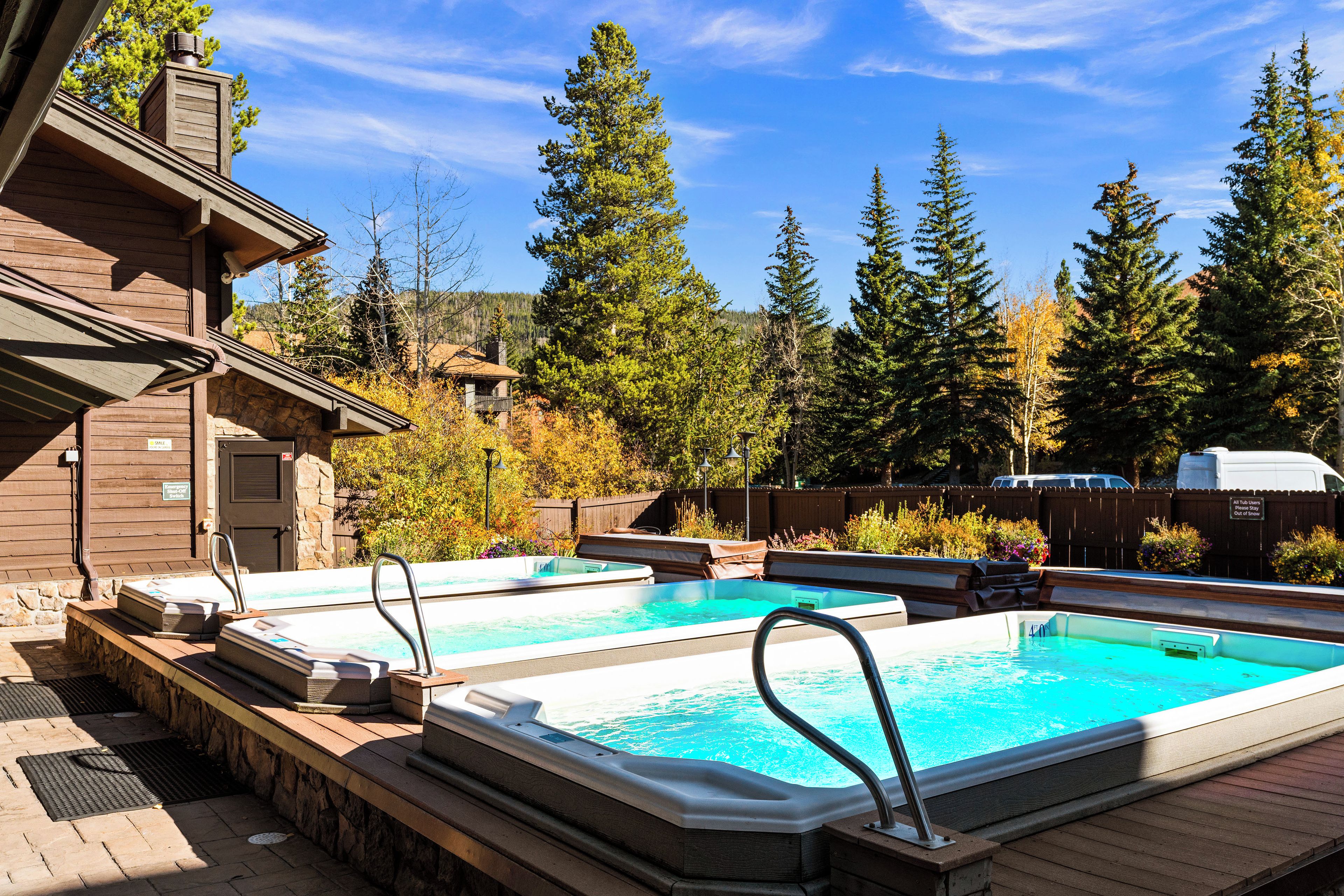A pool area with hot tubs and a wooden deck.