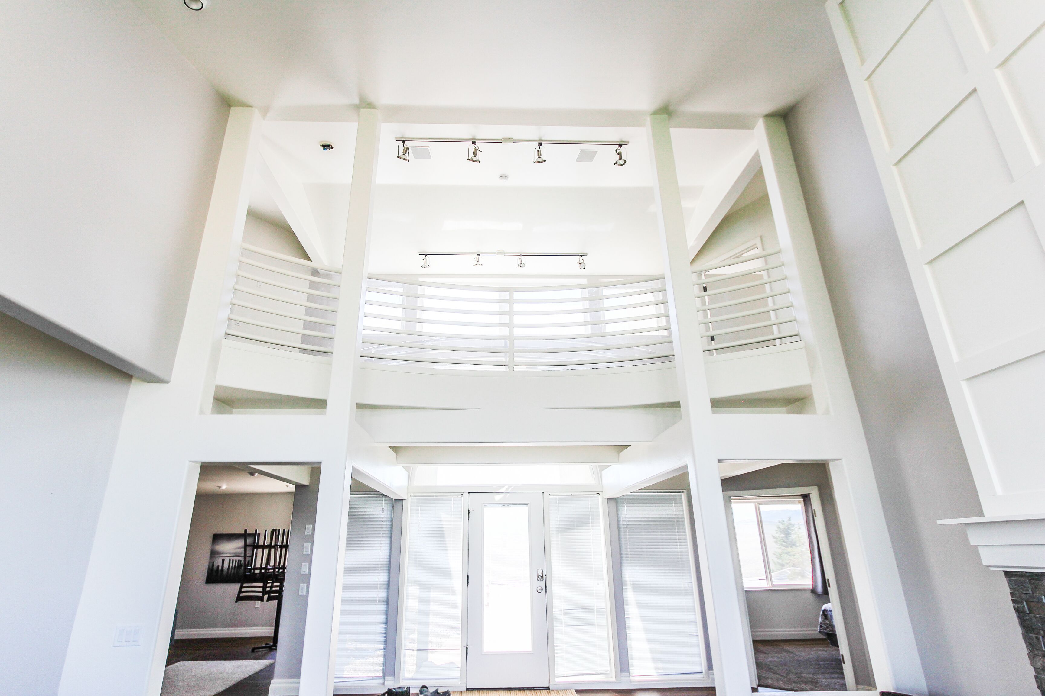 Un intérieur spacieux à plusieurs niveaux, doté d’un escalier central, de grandes fenêtres et d’un design moderne.