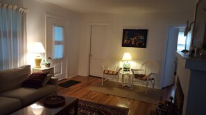 A living room with a sofa, two armchairs, a coffee table, and a painting on the wall.