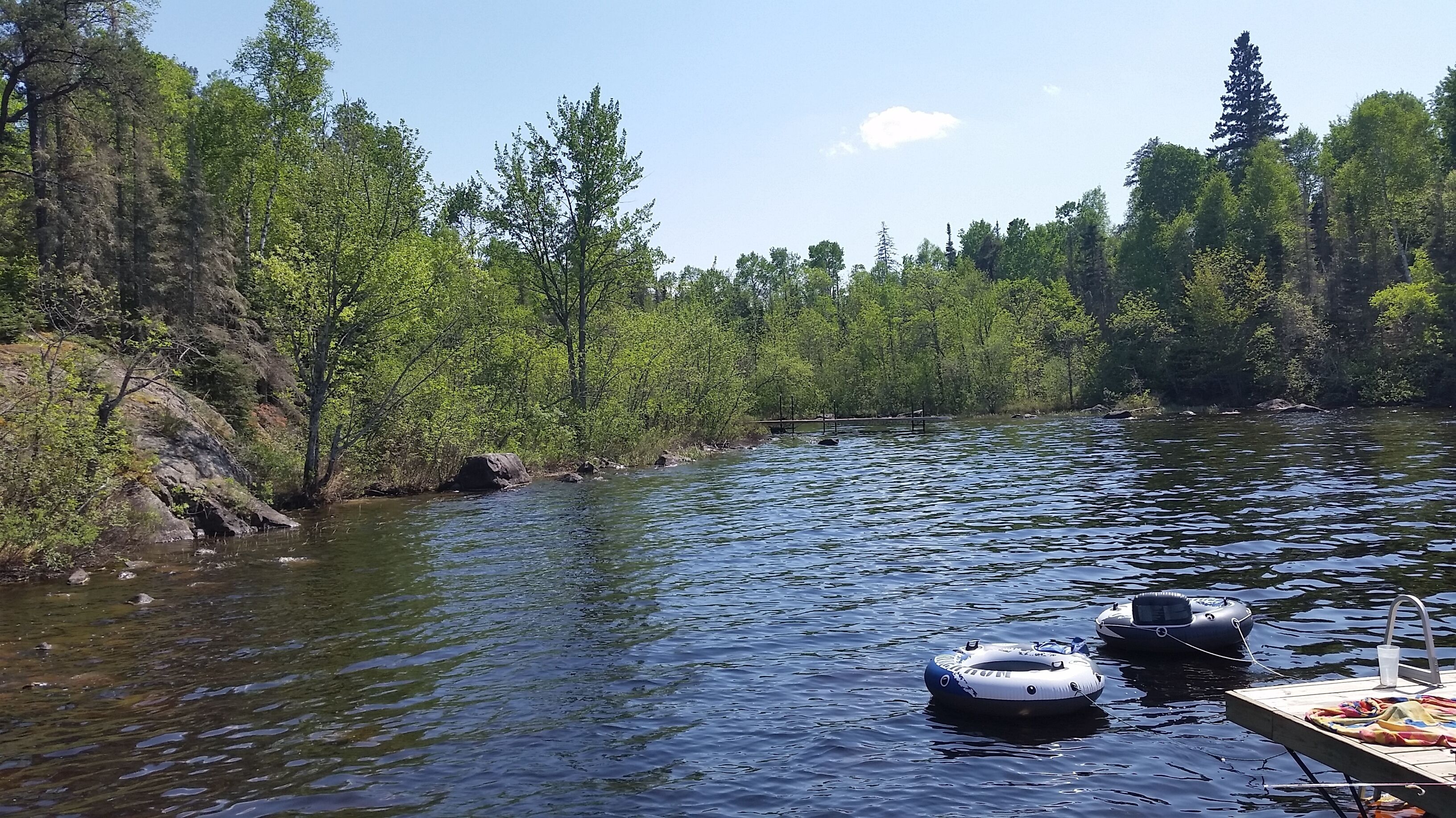 A river with two inflatable rafts floating on the water.