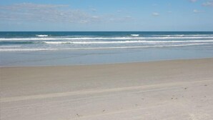 Een strand met een heldere lucht en rustige zee.