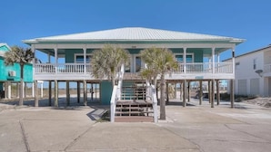 A two-story building with a balcony and a staircase leading to the upper floor. - 🌴Buckeye🌴Steps to Sand | Sleeps 8 w/ Gulf Views + Outdoor Shower (Navarre)