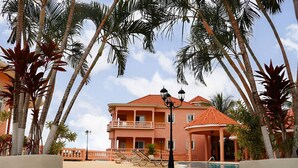 Un edificio a più piani con tetto in tegole rosse, un balcone e una zona piscina.