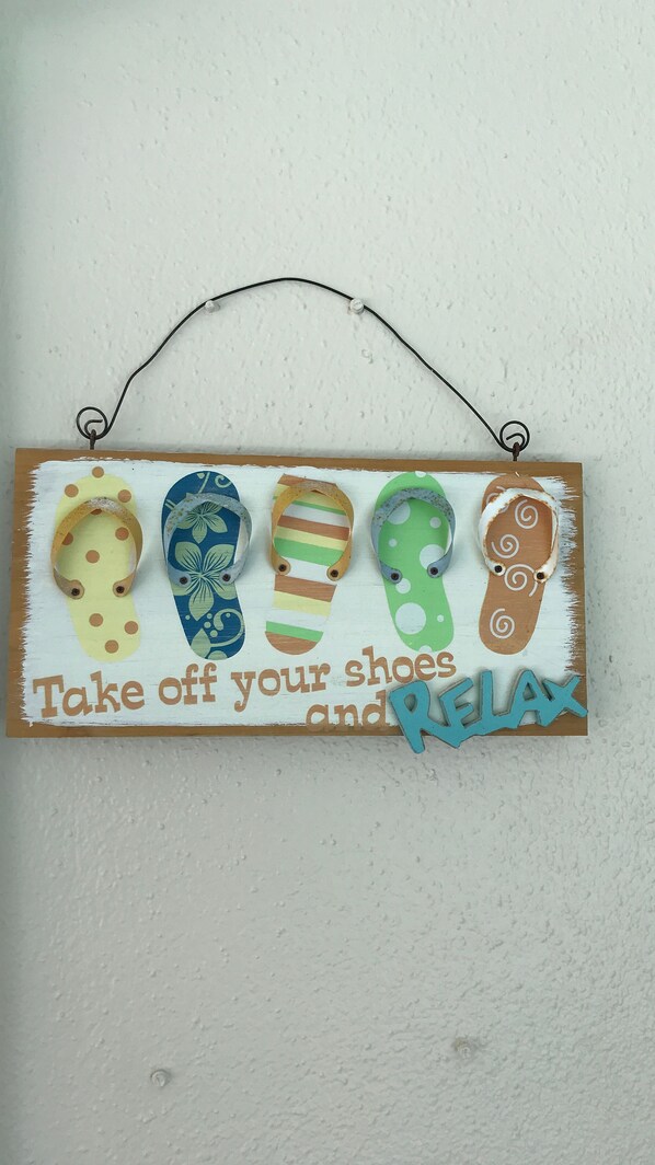 A wall-mounted sign with flip-flops and the text "Take off your shoes and RELAX."