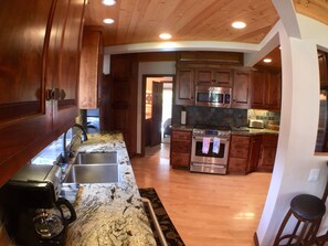 A kitchen with wooden cabinets, a stainless steel oven, a microwave, and a coffee maker.