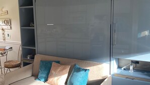 A living room with a sofa, a TV, and a desk with a computer.