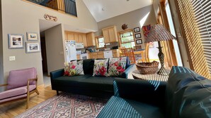 A spacious living area with a sofa, a dining table, and a kitchen in the background. - Heron Landing:  Escape to Lake Mayo.
Private cove, where nature abounds! 



 (Roxboro)