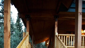 Una escalera de madera con barandilla que lleva a un porche cubierto.