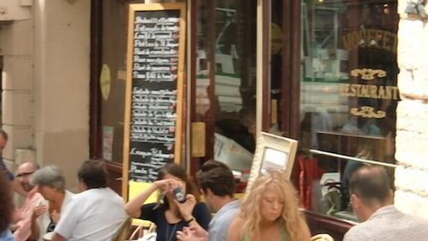 A restaurant with outdoor seating, a chalkboard menu, and ornate architectural details. - Luxury stay with champagne in an Artist's Atelier In The 5th (Paris)