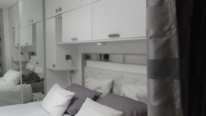 A modern bedroom with a large bed, white and gray bedding, a headboard with built-in lighting, and a wardrobe with mirrored doors. - Luxury stay with champagne in an Artist's Atelier In The 5th (Paris)