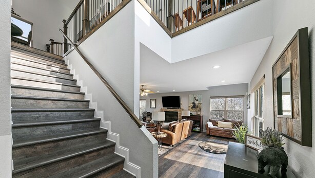 A spacious living area with a staircase, a fireplace, and a large window. - GREAT view DOWNTOWN Gatlinburg with views,community pool, hot tub and fireplace (Gatlinburg)