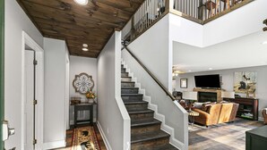 A spacious living area with a staircase, a fireplace, and a television. - GREAT view DOWNTOWN Gatlinburg with views,community pool, hot tub and fireplace (Gatlinburg)