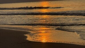 A sunset over a beach with waves.