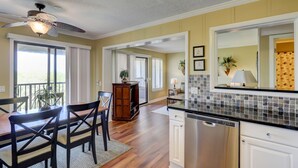 A kitchen with wooden cabinets, a dishwasher, and a dining area with a table and chairs.