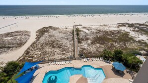 Ein Strandresort mit Swimmingpool, Strandliegen und Blick auf den Ozean.