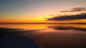 Uma praia com um pôr do sol.