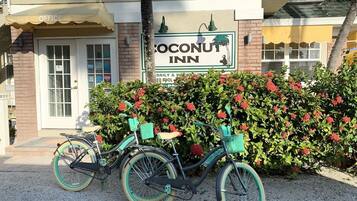 A building with a sign for 'Coconut Inn' and a bicycle parked in front.