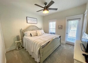 A bedroom with a bed, a ceiling fan, a small table, and a TV. - LazyLou-Scallop Season-Low Rates:4 Bedroom+4.5 Bath+Pools+Hot Tub+Screen Porches (Port St Joe)