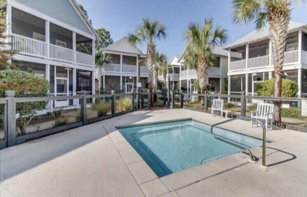 Relax by the resort's central pool, surrounded by a deck area and multiple-story buildings with balconies offering scenic views.