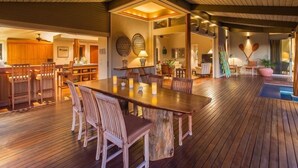 A spacious wooden deck with a dining area, kitchen, and living spaces.